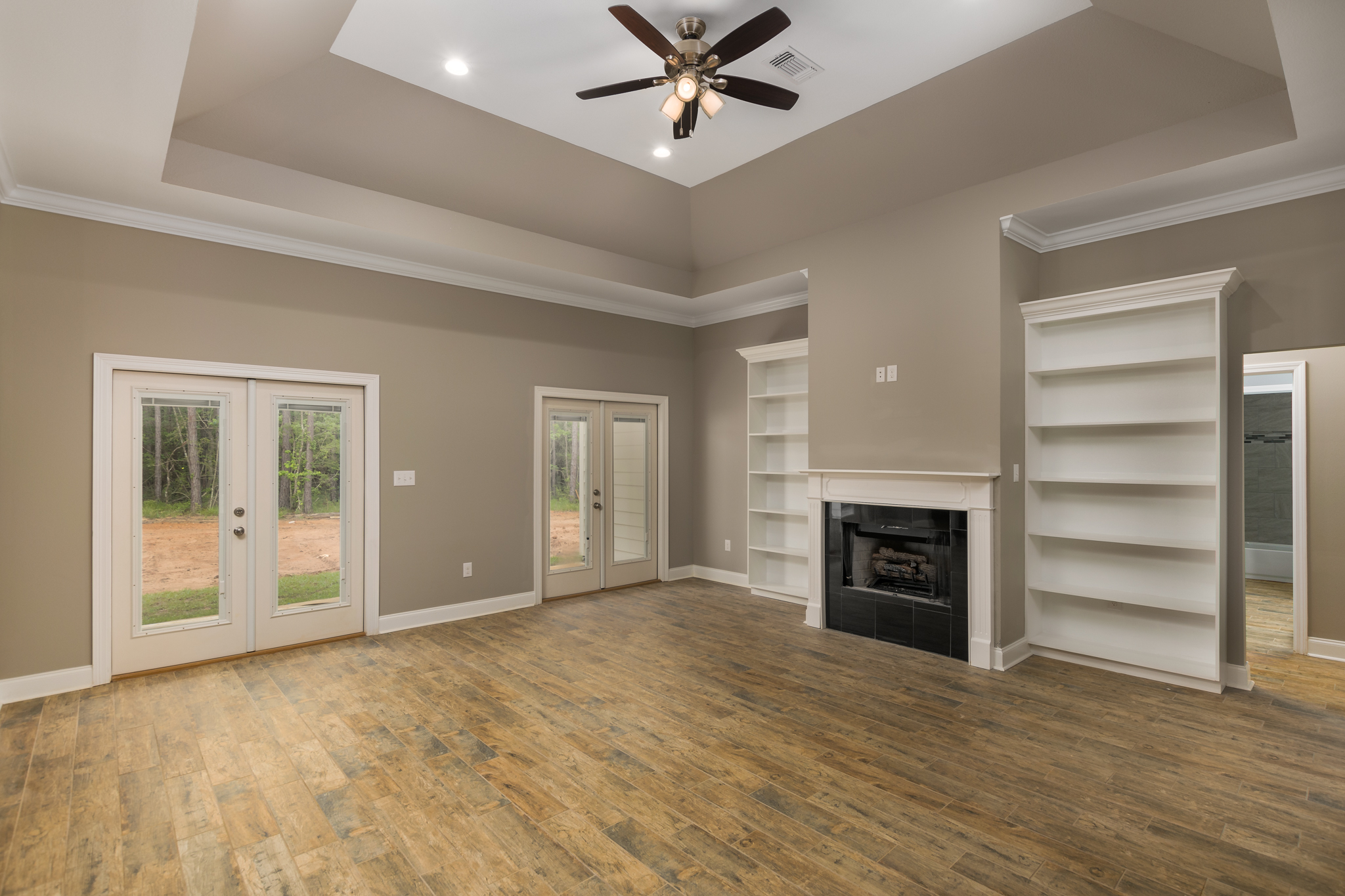 custom living room with custom shelving and tray ceilings