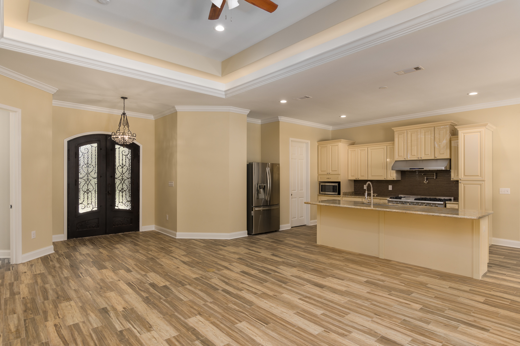 custom interior home with LVP flooring, tray ceilings and gourmet kitchen